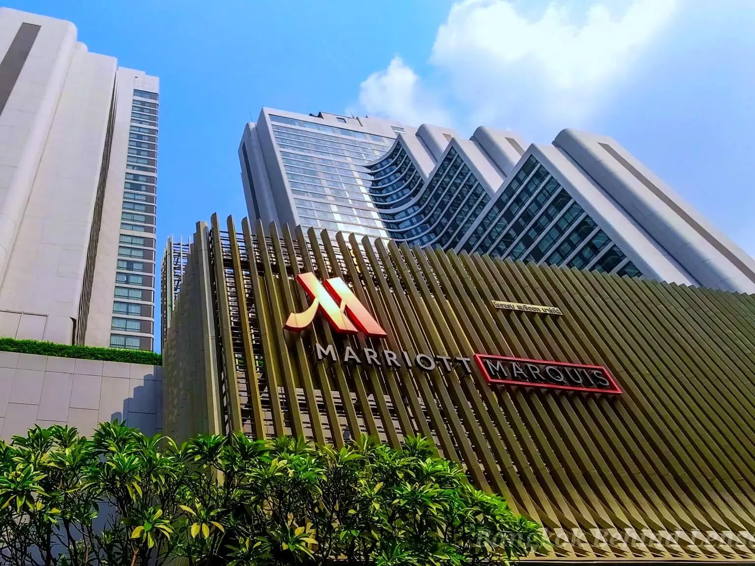 Bangkok Marriott Marquis hotel exterior with distinctive angular architecture and illuminated Marriott Marquis signage under blue sky